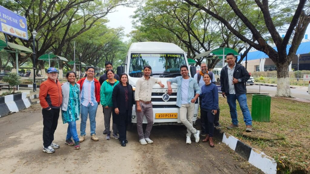 Travellers beside a parked tour vehicle